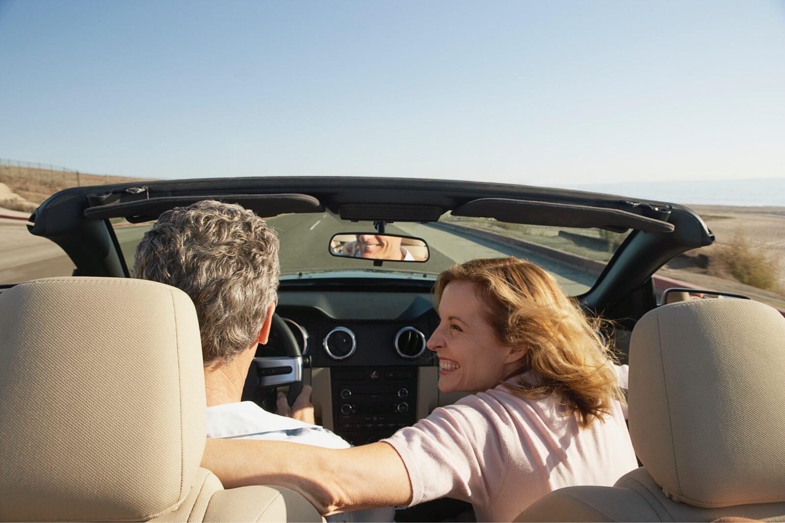 Pareja en un descapotable en una carretera